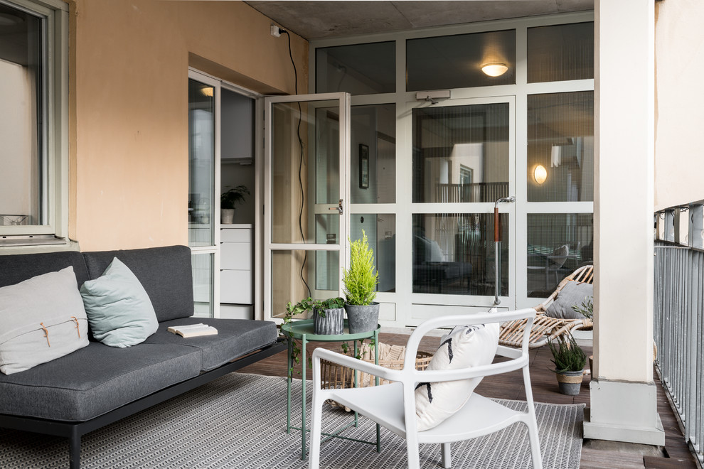 Exemple d'une terrasse scandinave avec une extension de toiture.