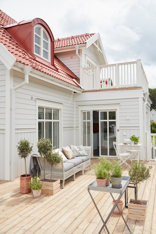 На фото: терраса среднего размера на заднем дворе в скандинавском стиле без защиты от солнца с