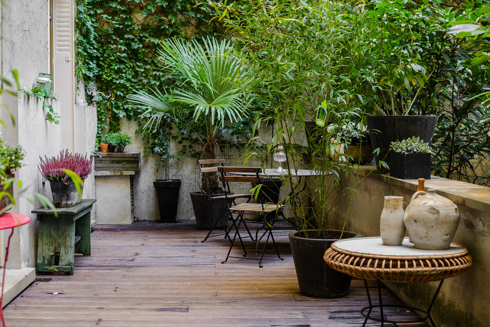 Mid-sized trendy courtyard patio container garden photo in Paris with decking and no cover