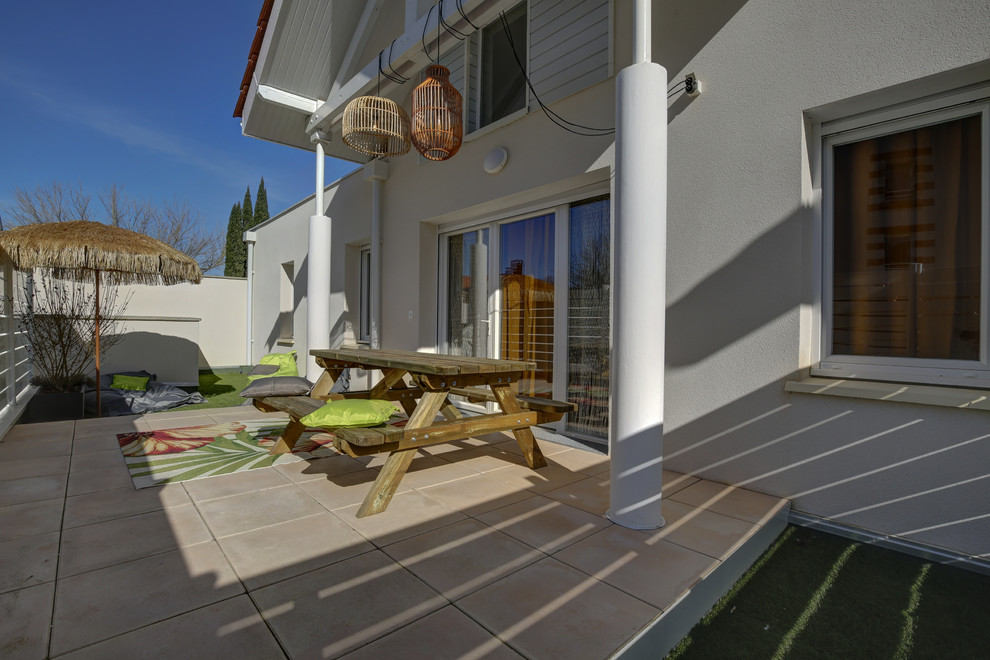 Immagine di un patio o portico eclettico di medie dimensioni e davanti casa con piastrelle