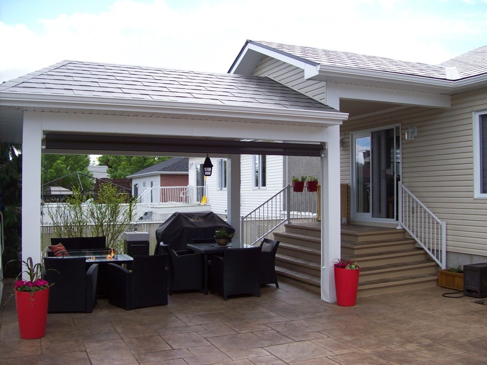 Esempio di un patio o portico tradizionale di medie dimensioni e dietro casa con piastrelle e un tetto a sbalzo
