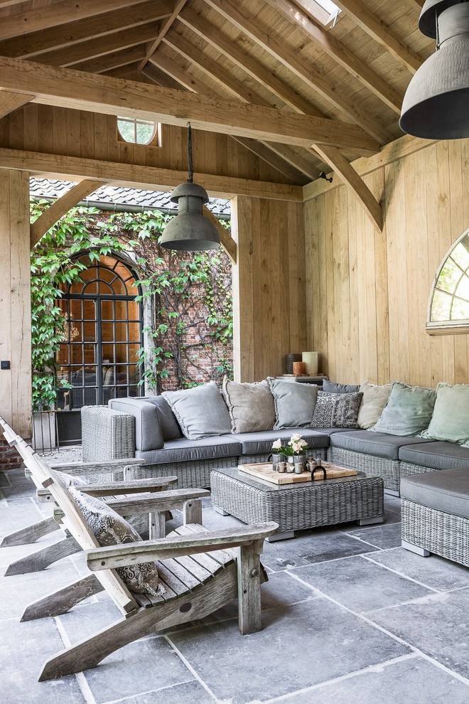 Foto de patio de estilo de casa de campo con adoquines de piedra natural y cenador