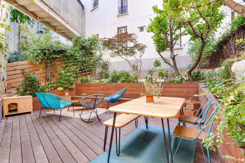 Ejemplo de terraza planta baja escandinava de tamaño medio sin cubierta en patio trasero con jardín de macetas y barandilla de madera
