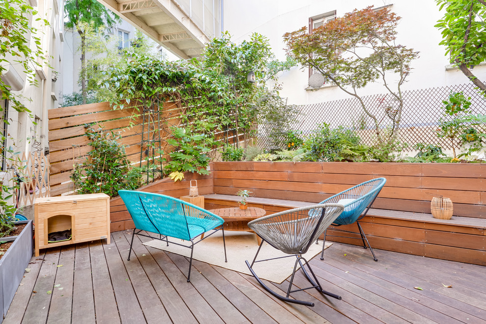 Ejemplo de terraza planta baja escandinava de tamaño medio sin cubierta en patio trasero con jardín de macetas y barandilla de madera