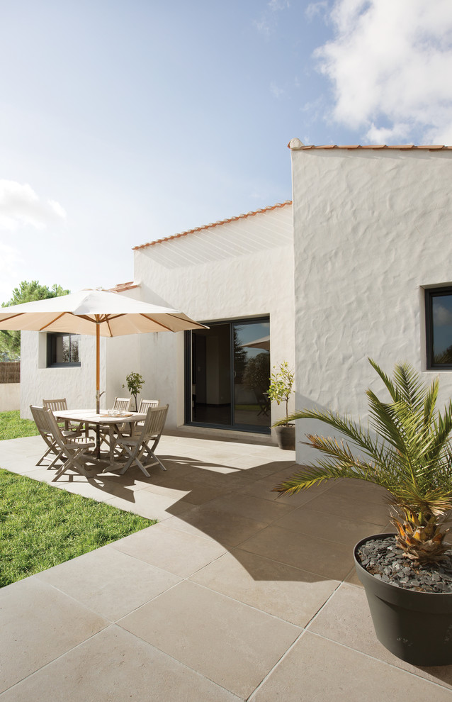 Imagen de patio mediterráneo de tamaño medio sin cubierta en patio trasero con jardín de macetas y suelo de baldosas