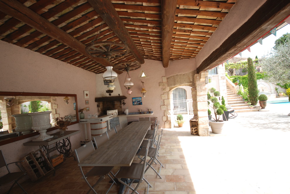 На фото: большой двор на заднем дворе в стиле кантри с летней кухней, покрытием из каменной брусчатки и навесом с