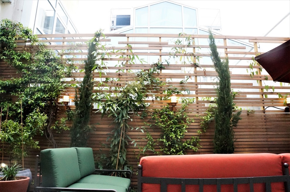 Свежая идея для дизайна: маленький двор в средиземноморском стиле с растениями в контейнерах и настилом для на участке и в саду - отличное фото интерьера