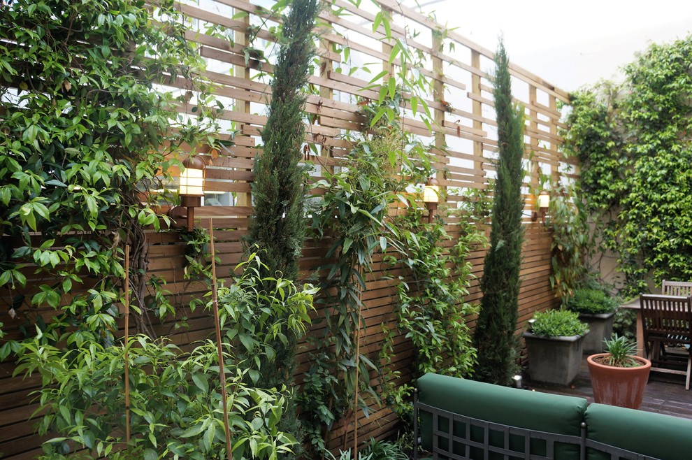 Источник вдохновения для домашнего уюта: маленький двор в средиземноморском стиле с растениями в контейнерах и настилом для на участке и в саду