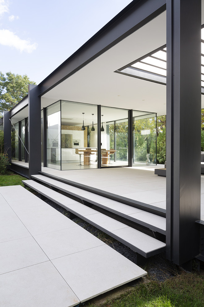 Réalisation d'une terrasse avant minimaliste de taille moyenne avec du carrelage et une pergola.