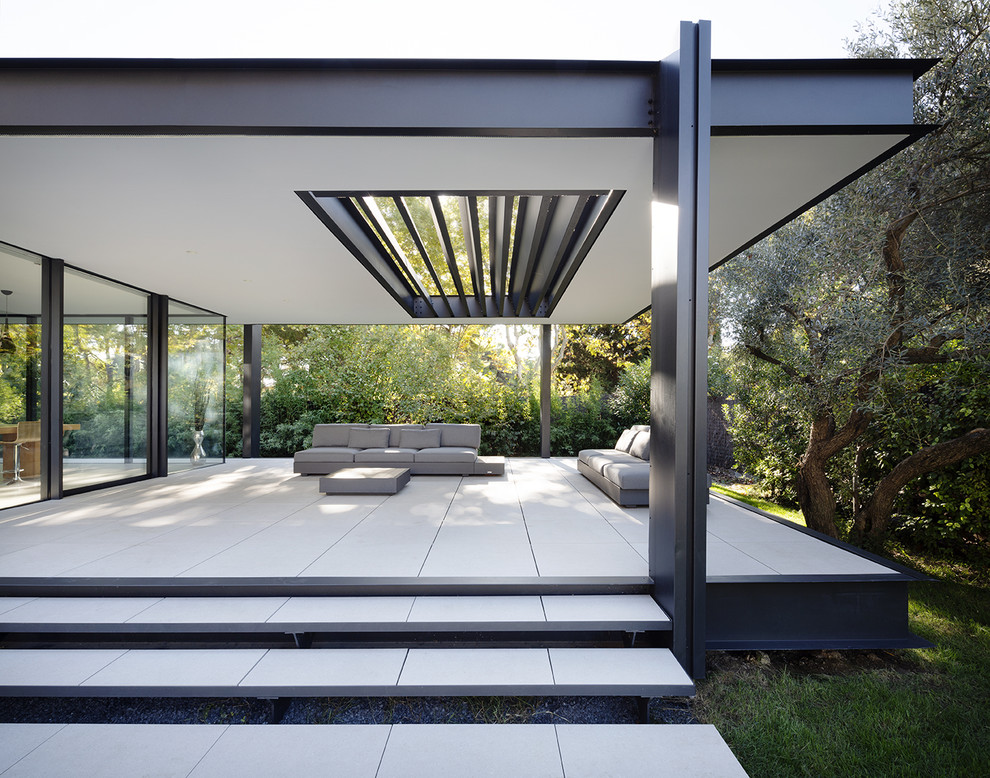 Imagen de patio moderno de tamaño medio en patio delantero y anexo de casas con suelo de baldosas