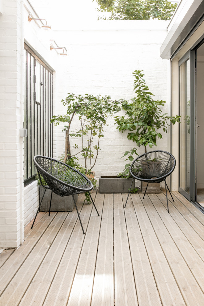 На фото: двор на переднем дворе в скандинавском стиле с мощением клинкерной брусчаткой без защиты от солнца
