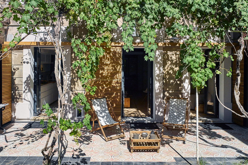Idée de décoration pour une terrasse méditerranéenne de taille moyenne avec une cour, des pavés en pierre naturelle et une pergola.