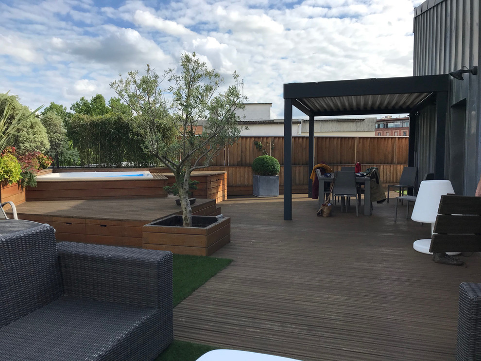 Medium sized contemporary patio in Toulouse with a living wall, decking and a pergola.