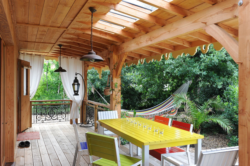 Photo of a large bohemian back terrace in Other with a roof extension.