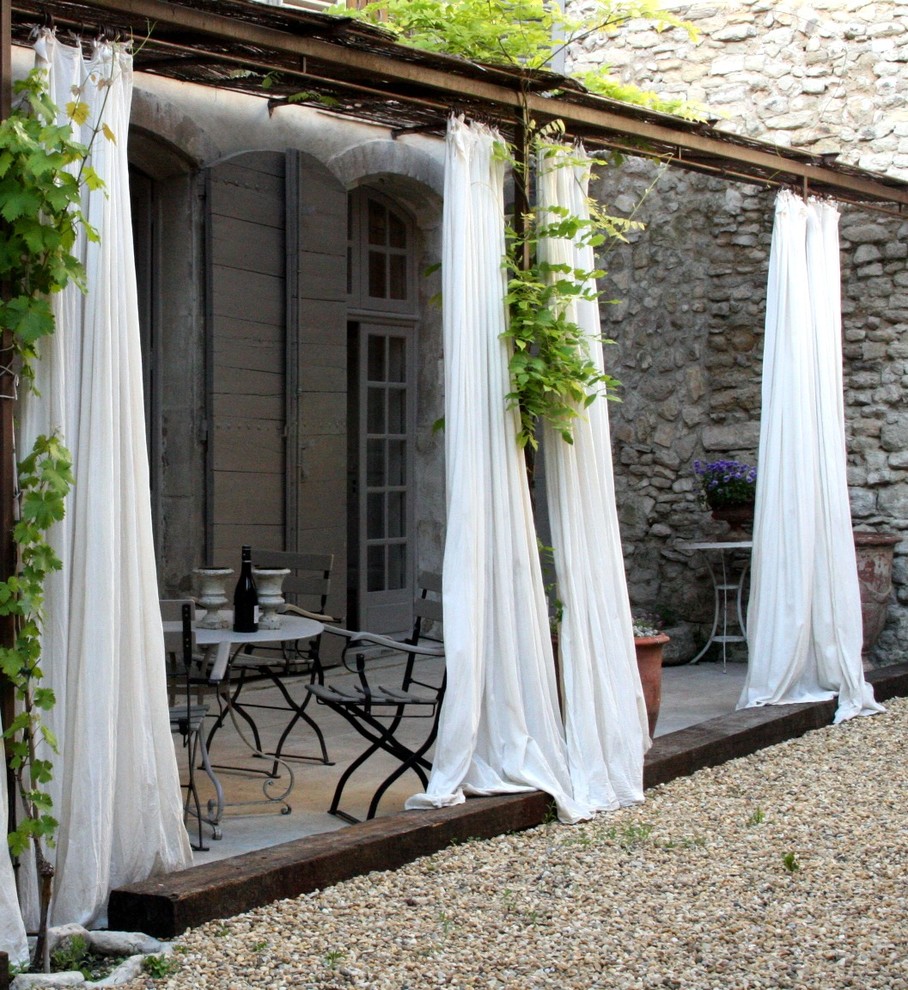 Medium sized romantic patio in Other with a pergola.