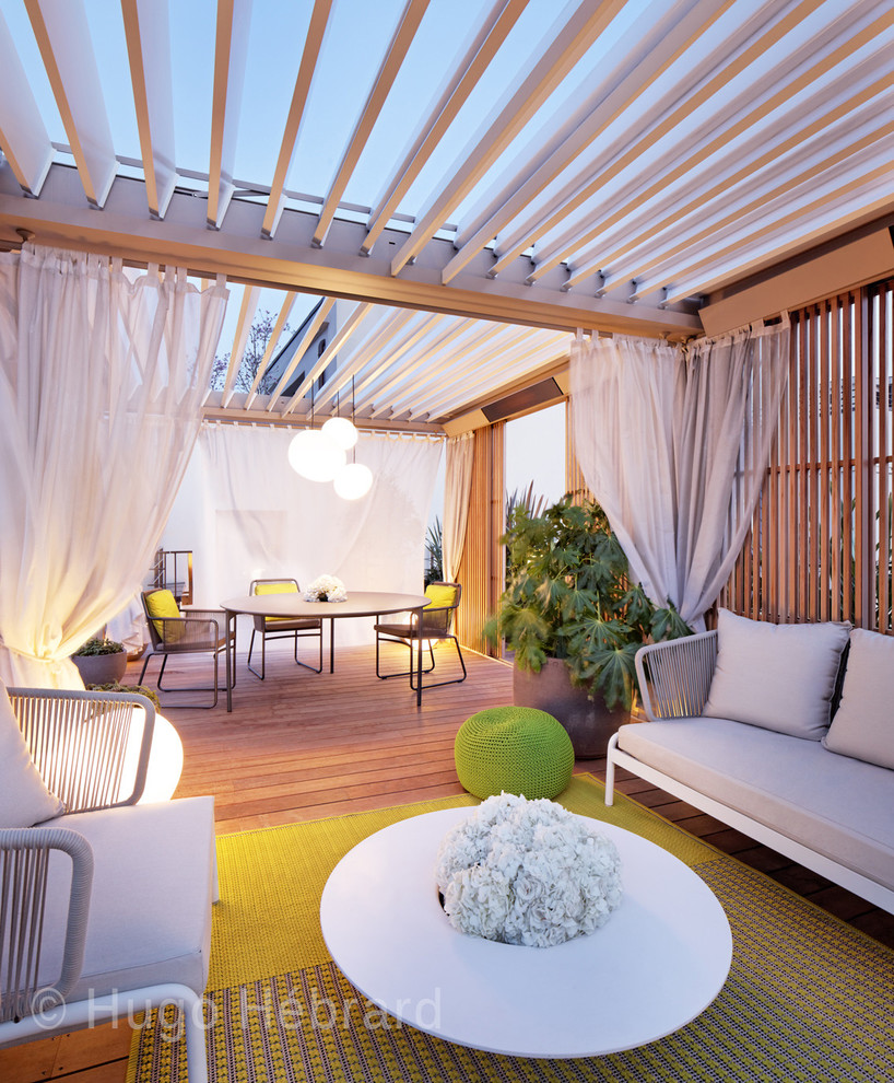 Diseño de terraza tropical de tamaño medio en azotea con jardín de macetas y pérgola