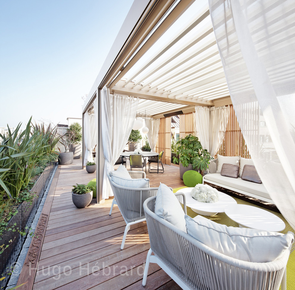 Modelo de terraza exótica de tamaño medio en azotea con jardín de macetas y pérgola