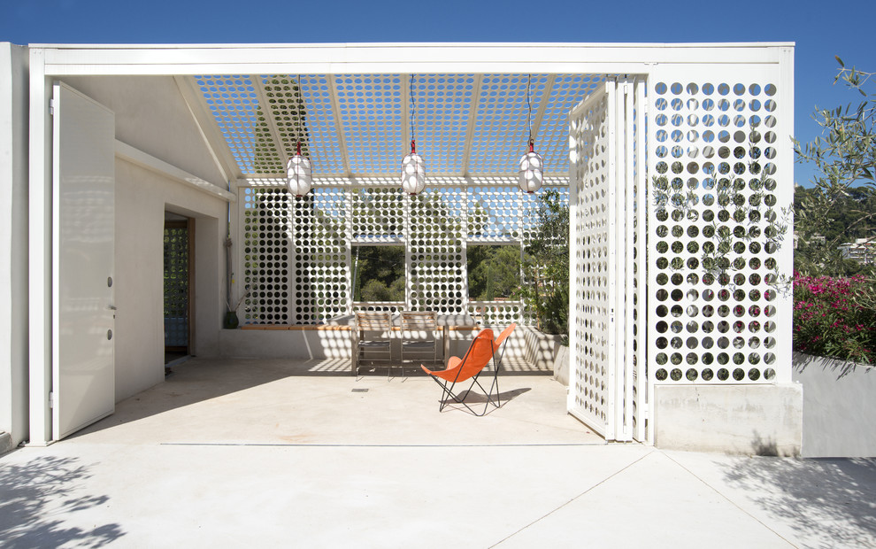 Cette image montre une terrasse latérale design de taille moyenne avec une dalle de béton et une pergola.