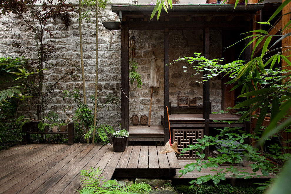 Inspiration för stora asiatiska terrasser längs med huset, med markiser och utekrukor
