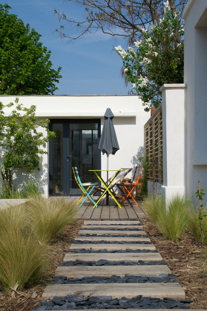 На фото: терраса среднего размера на заднем дворе в морском стиле без защиты от солнца с