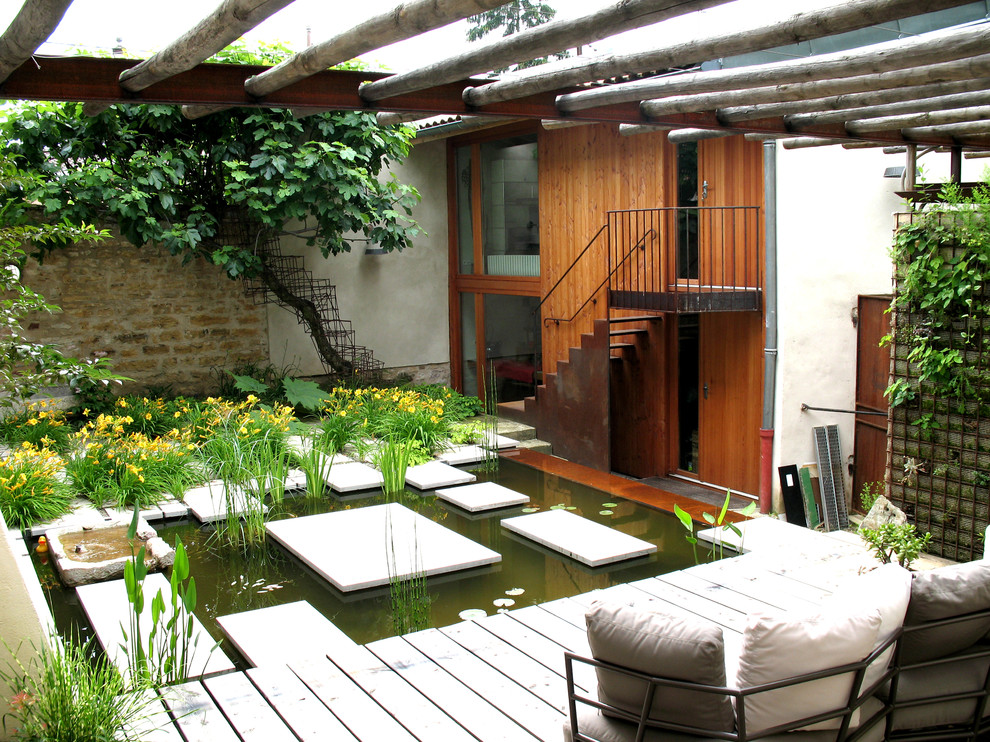 Idées déco pour une terrasse en bois arrière éclectique de taille moyenne avec un point d'eau et une pergola.