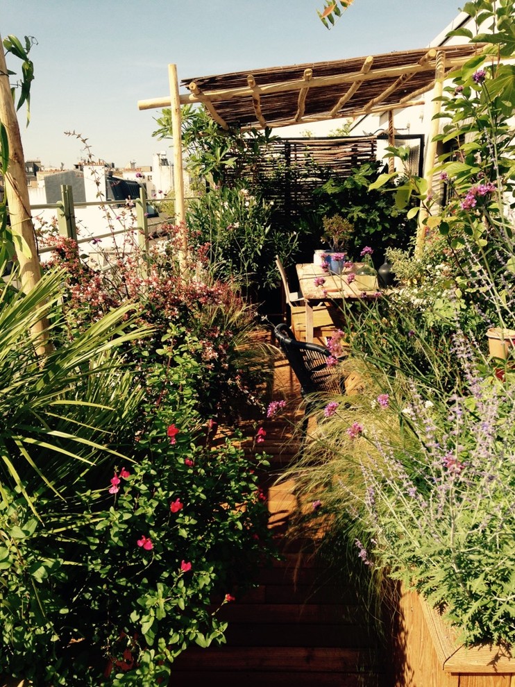 На фото: маленькая терраса в стиле фьюжн с растениями в контейнерах для на участке и в саду