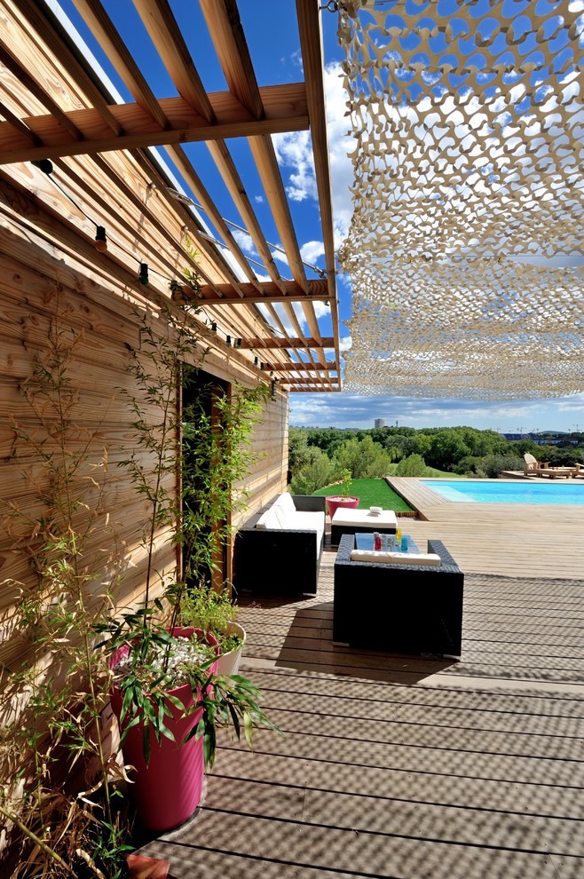 Источник вдохновения для домашнего уюта: большая пергола на террасе на заднем дворе в средиземноморском стиле с растениями в контейнерах