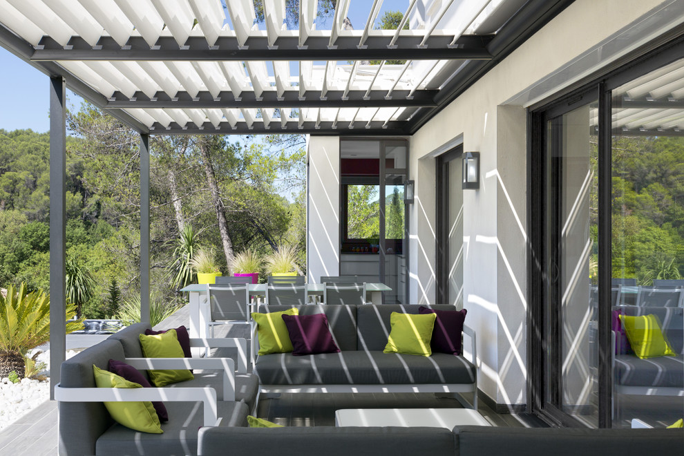 Idée de décoration pour une terrasse avant design avec une pergola.