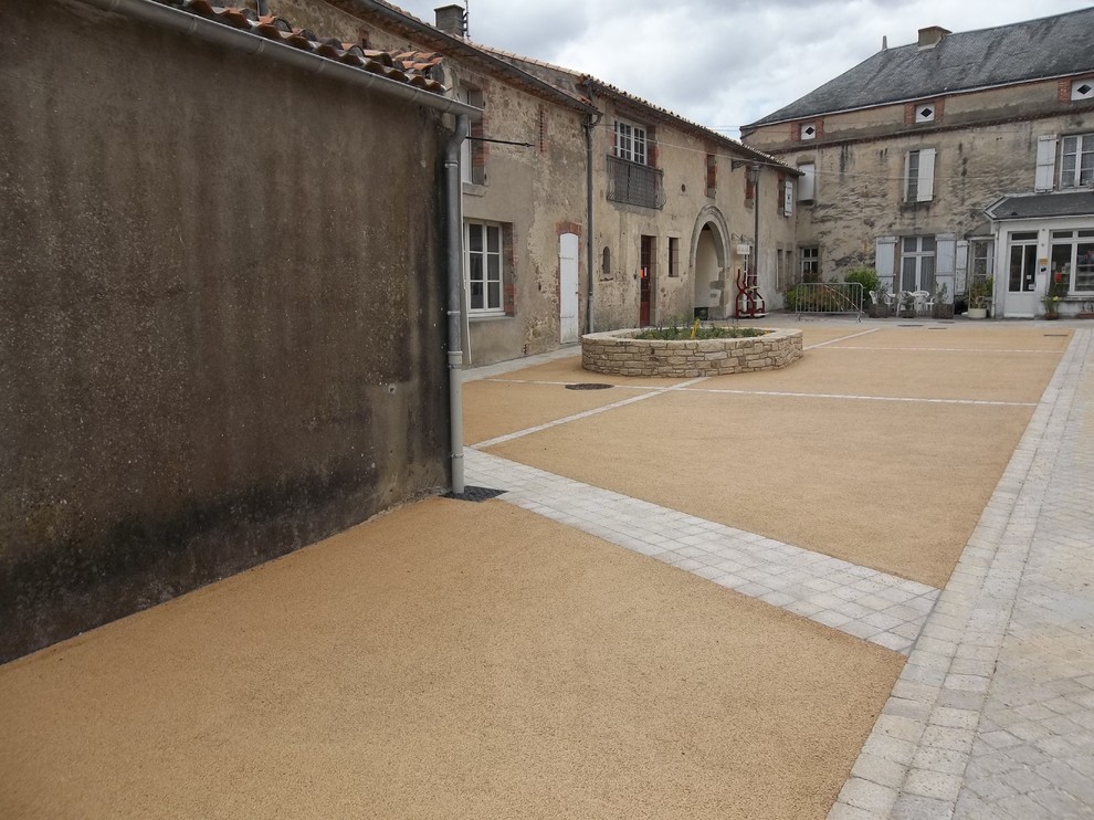 This is an example of a country patio in Nantes with stamped concrete.