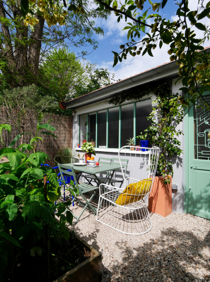 Modelo de patio moderno de tamaño medio en patio delantero con huerto y gravilla