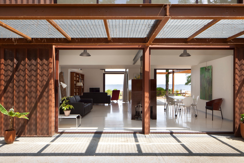Ispirazione per un patio o portico minimal di medie dimensioni e dietro casa con pavimentazioni in cemento e una pergola