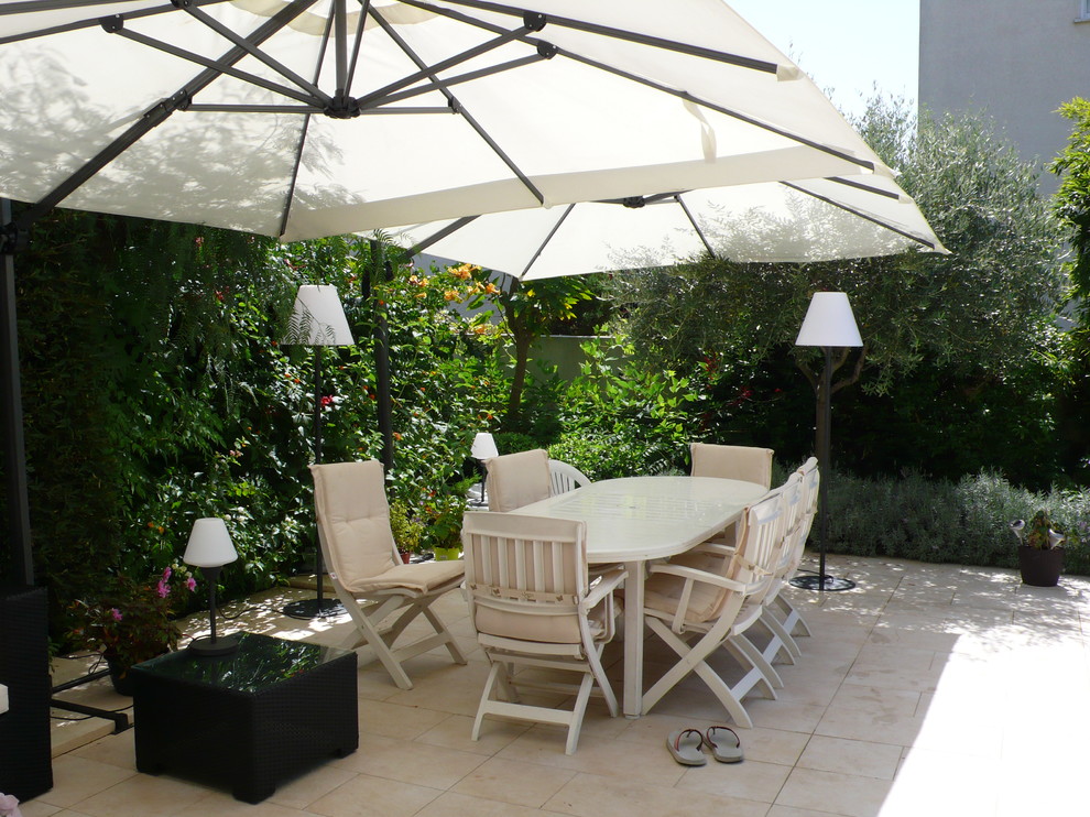 Стильный дизайн: большой двор на заднем дворе в современном стиле с покрытием из плитки, вертикальным садом и козырьком - последний тренд