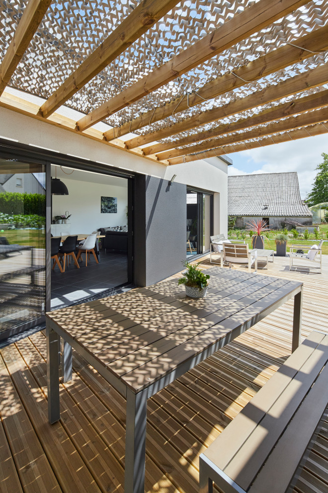 Réalisation d'une terrasse arrière minimaliste de taille moyenne avec une pergola.