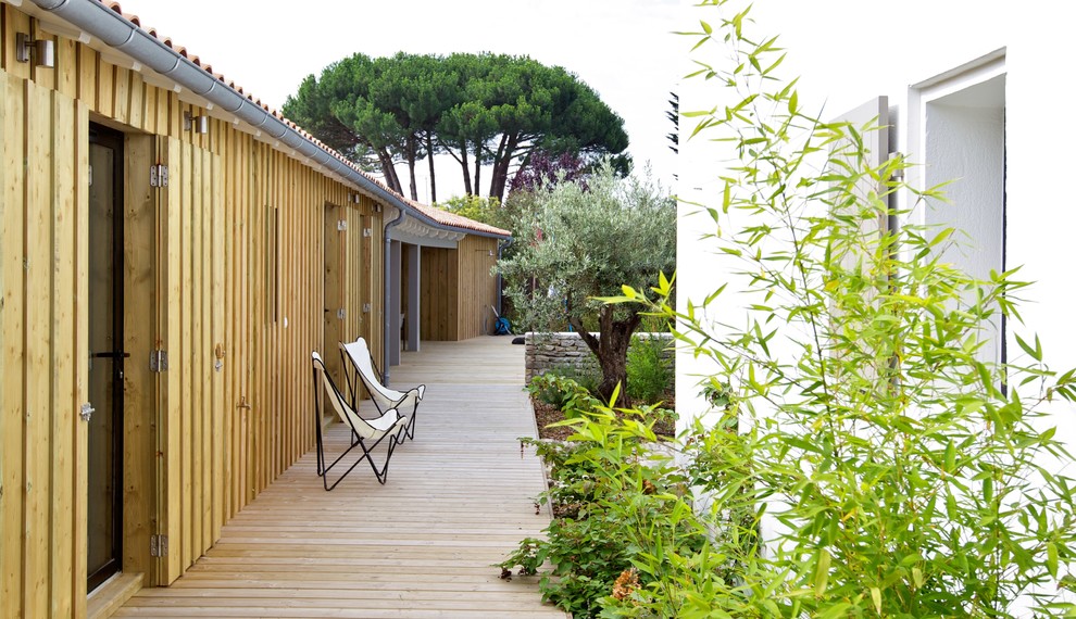 Example of a large tuscan side yard deck design in Paris