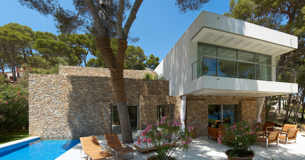 Foto di un patio o portico mediterraneo di medie dimensioni e dietro casa con lastre di cemento e un tetto a sbalzo