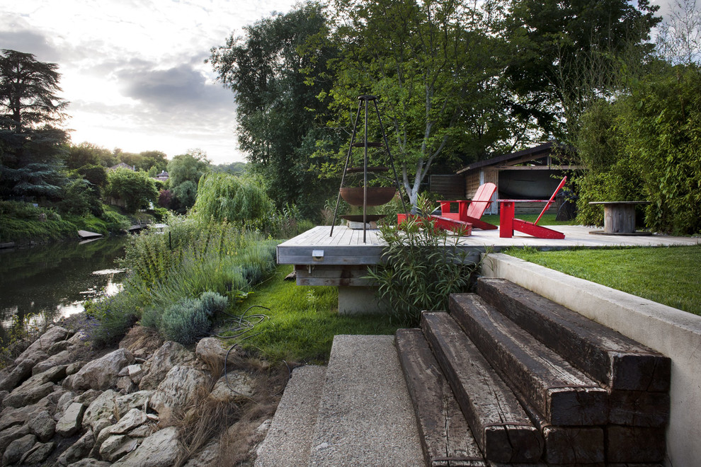 Modelo de terraza planta baja de estilo de casa de campo de tamaño medio sin cubierta en patio trasero con brasero