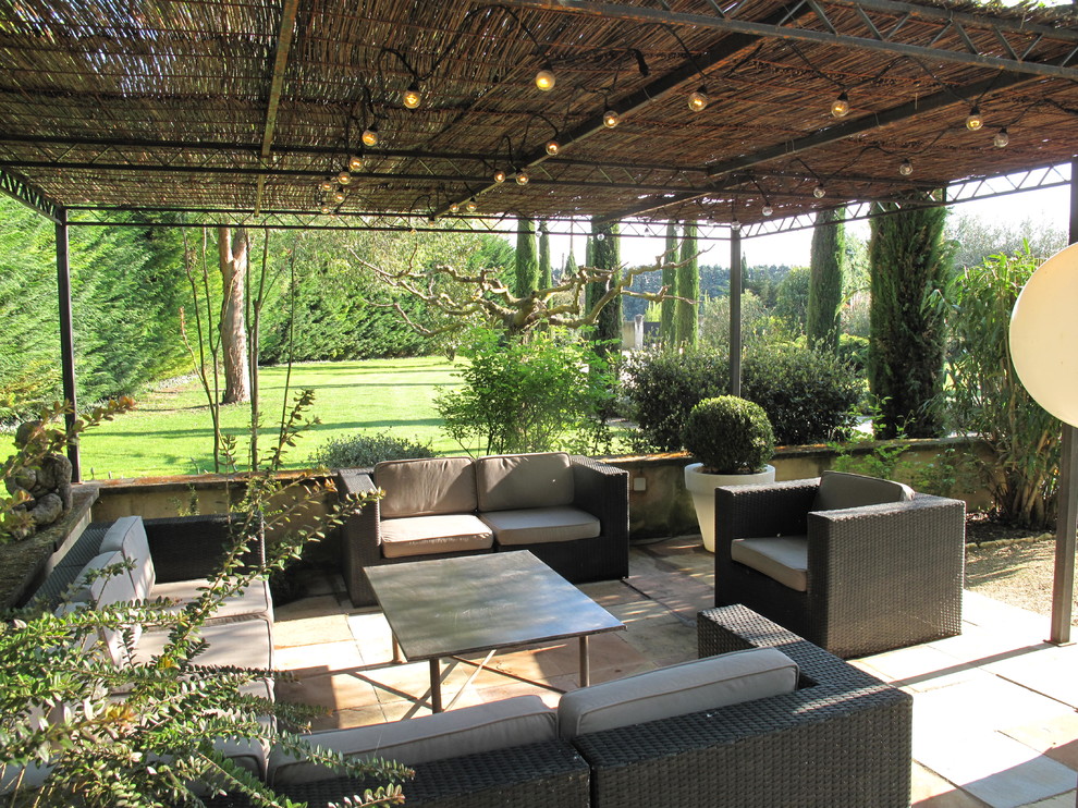 Imagen de patio mediterráneo de tamaño medio en patio trasero con brasero, adoquines de piedra natural y toldo