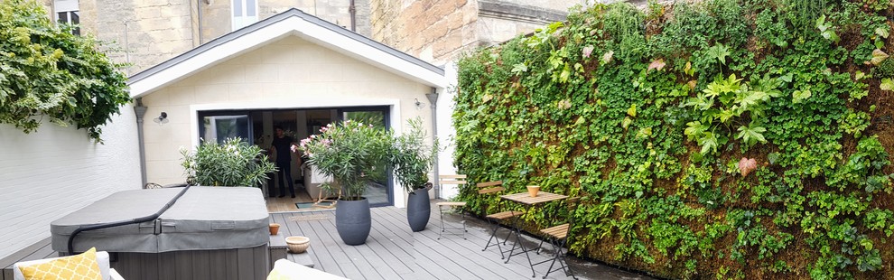 Photo of a medium sized contemporary back terrace in Bordeaux with a living wall and no cover.