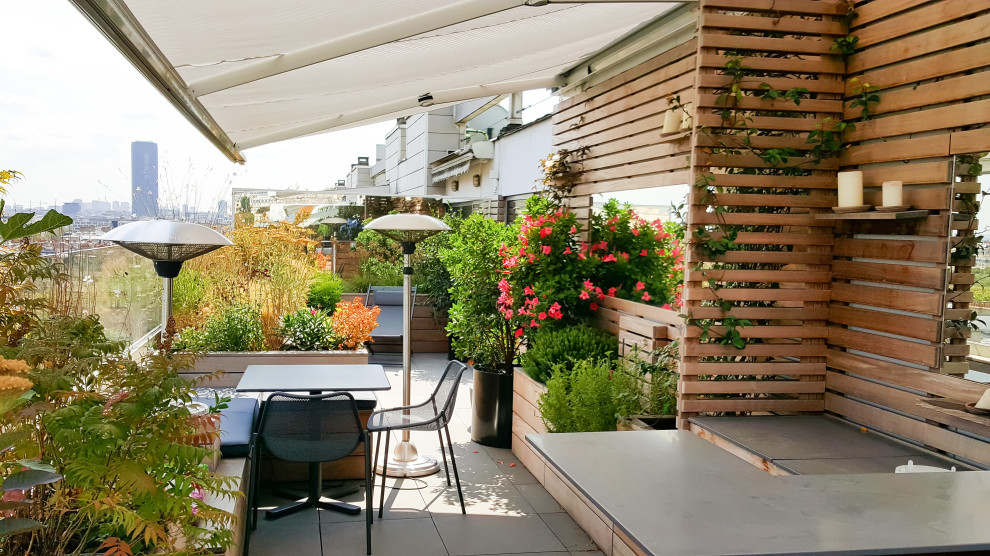 Aménagement d'une grande terrasse arrière contemporaine avec une cuisine d'été, du carrelage et un auvent.
