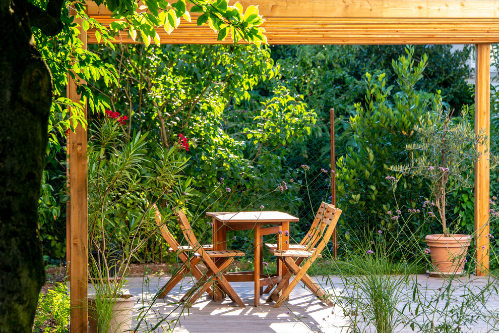 Cette photo montre une terrasse en bois arrière tendance de taille moyenne avec une pergola.