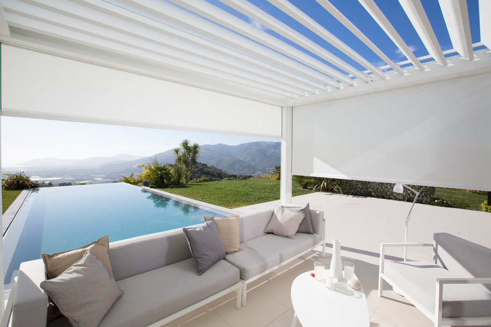 Réalisation d'une grande terrasse design avec du carrelage et une pergola.