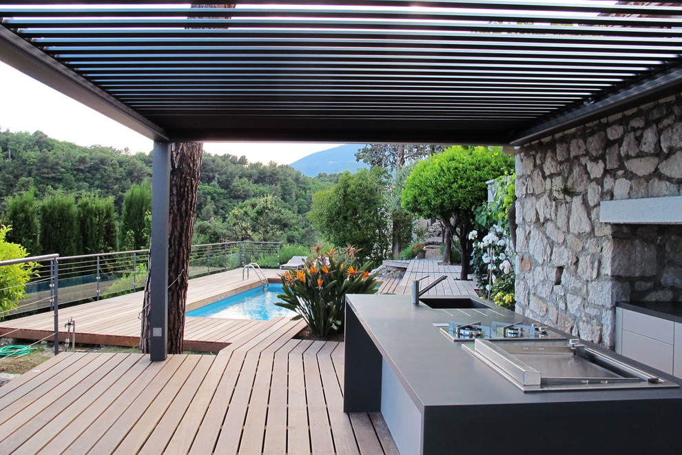 Свежая идея для дизайна: большая пергола на террасе на заднем дворе в средиземноморском стиле с летней кухней - отличное фото интерьера