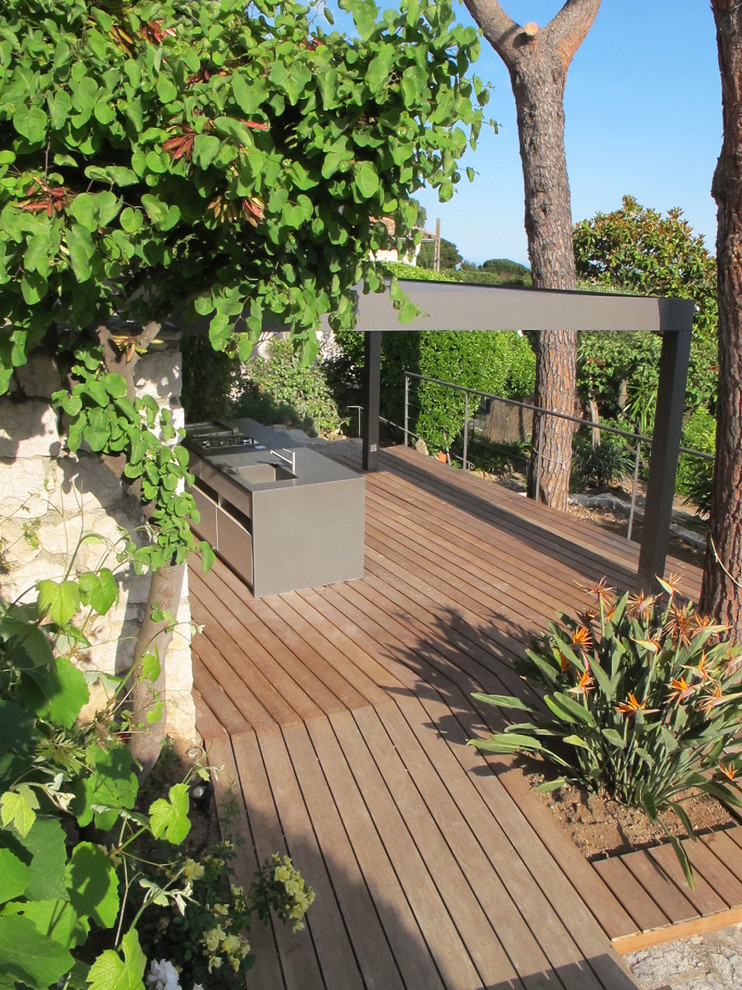 Foto de terraza mediterránea grande en patio trasero con cocina exterior y pérgola