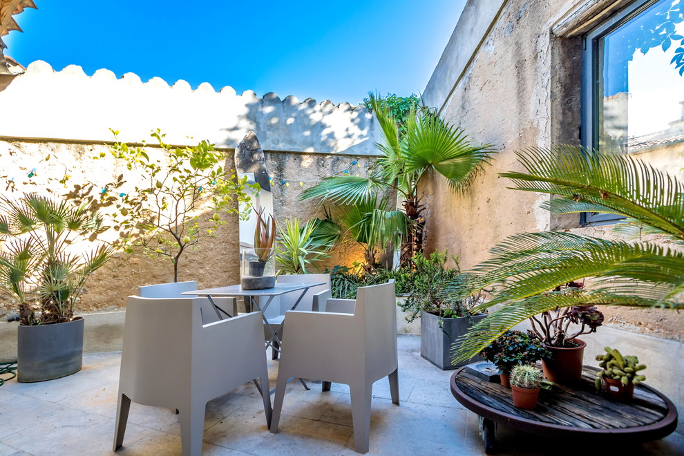 Diseño de patio mediterráneo de tamaño medio sin cubierta con jardín de macetas y adoquines de piedra natural
