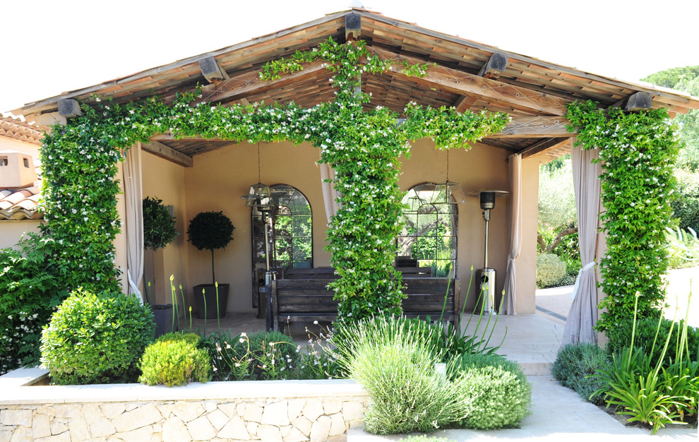 Стильный дизайн: двор среднего размера на заднем дворе в средиземноморском стиле с покрытием из каменной брусчатки, навесом и вертикальным садом - последний тренд