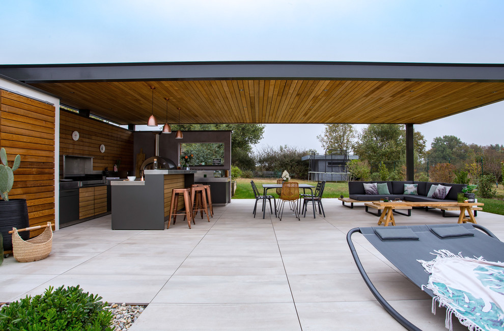 Réalisation d'une terrasse arrière design de taille moyenne avec une cuisine d'été, du carrelage et une pergola.