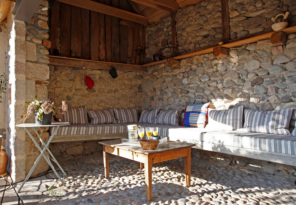 Ejemplo de patio de estilo de casa de campo de tamaño medio en patio lateral y anexo de casas con adoquines de piedra natural