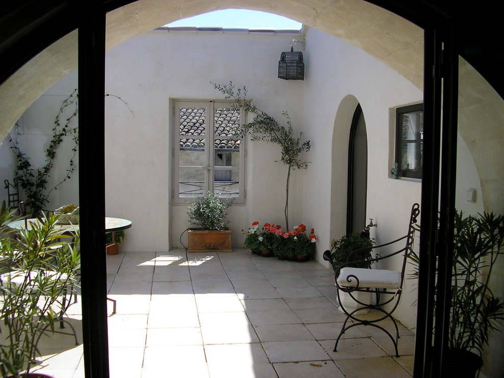 Ejemplo de patio campestre grande sin cubierta en patio delantero con jardín de macetas y adoquines de piedra natural