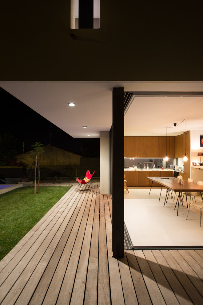 Idee per un patio o portico minimal dietro casa con pedane e un tetto a sbalzo