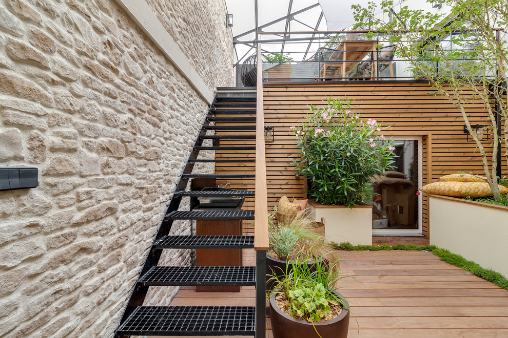 Réalisation d'une terrasse design avec une cuisine d'été, une cour et une extension de toiture.